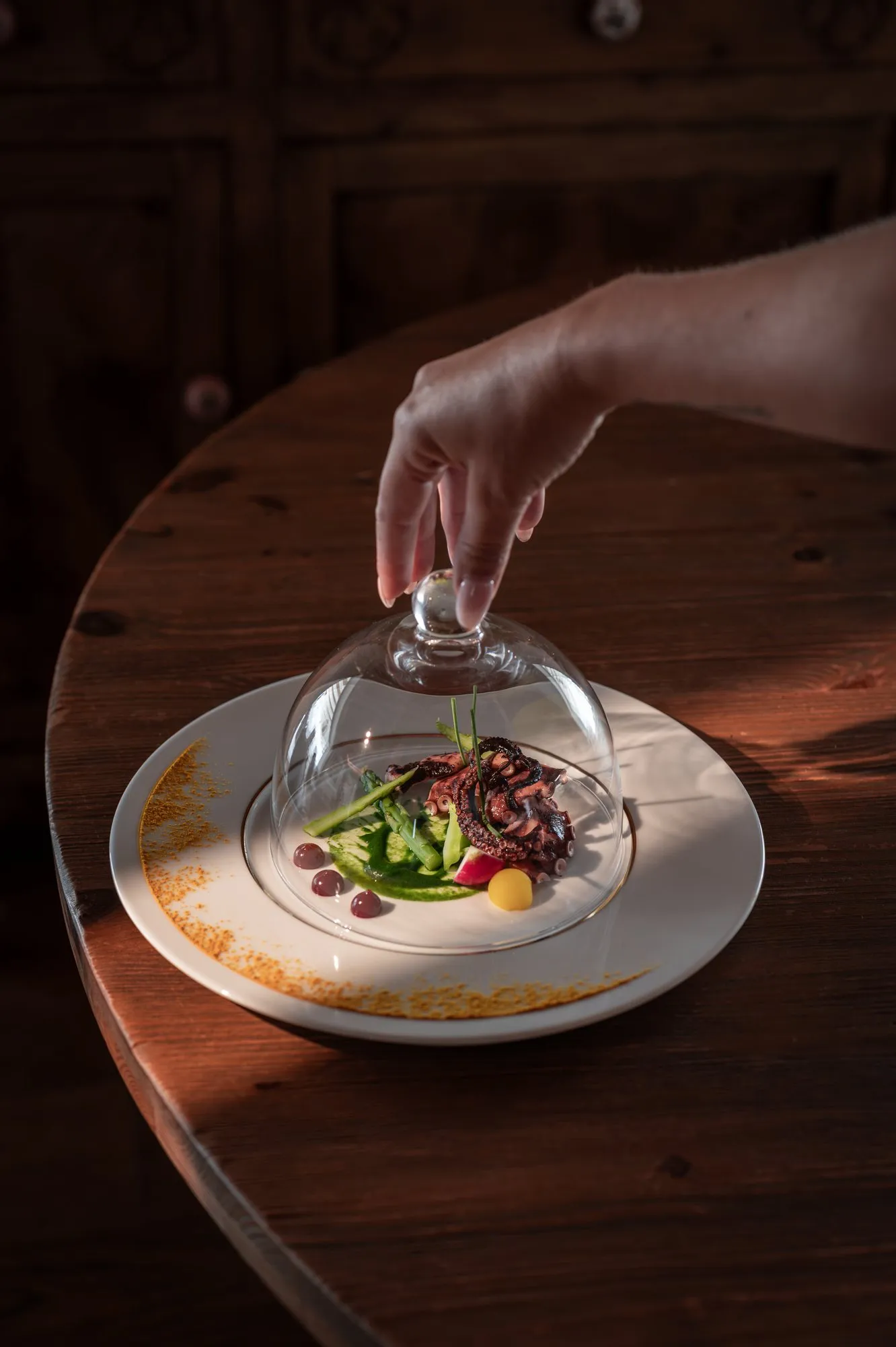 A dish revealed from beneath a glass dome